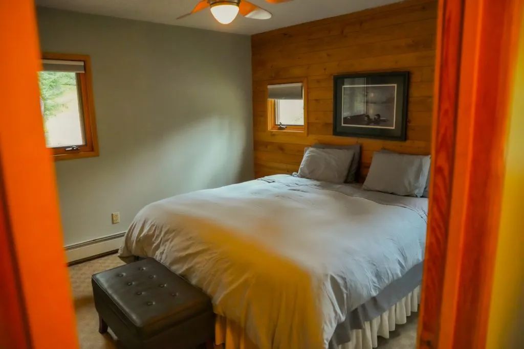 A bedroom with a king size bed and a ceiling fan.