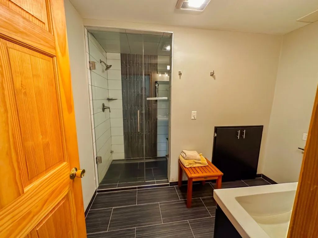 A bathroom with a walk in shower and a sink