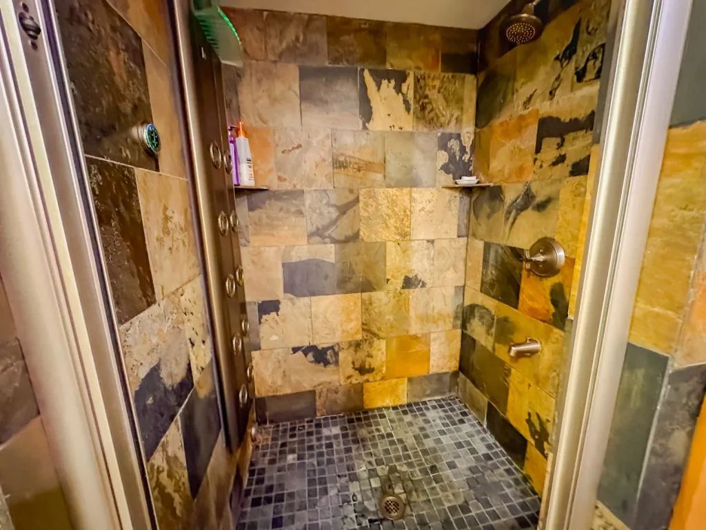 A bathroom with a walk in shower and tiled walls.