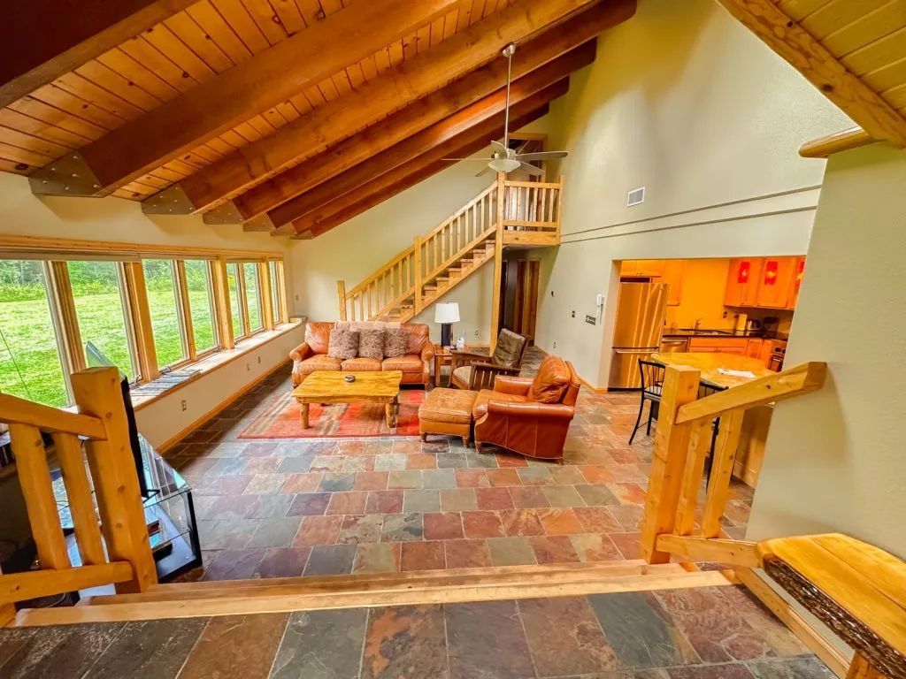 A living room with a staircase leading up to the second floor.
