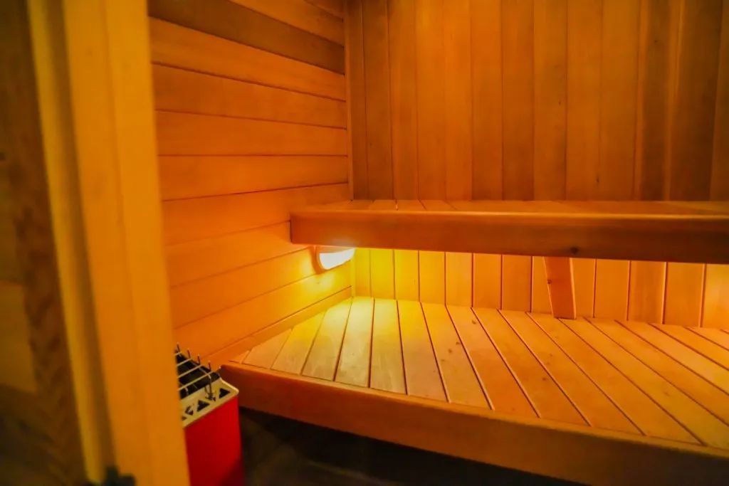 A wooden sauna with a red box in the corner.