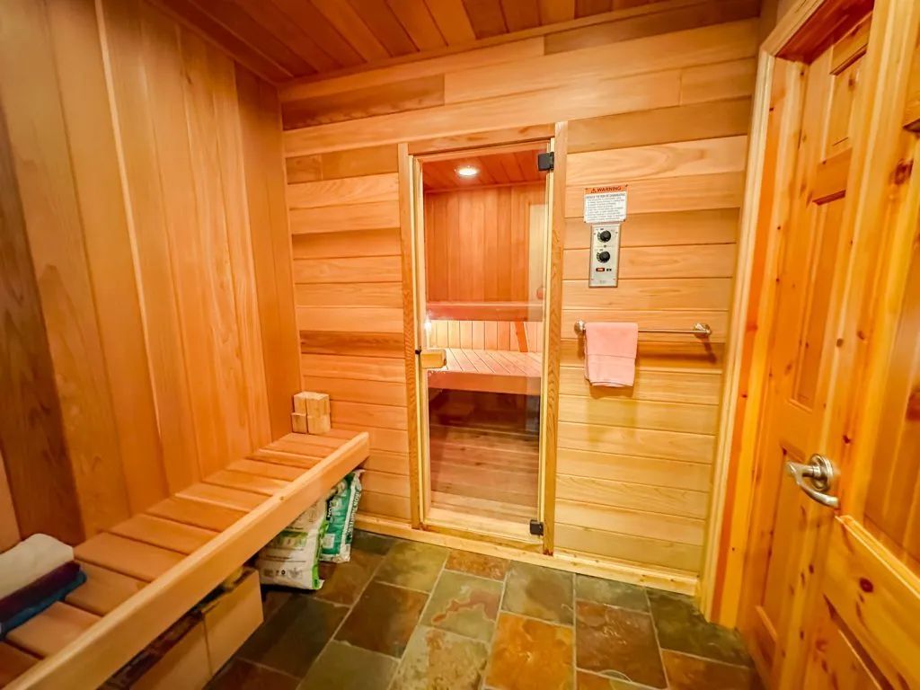 A wooden sauna with a bench and a glass door.
