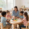 A teacher sits at a wooden table with four students, working on activities with colorful blocks in a classroom.