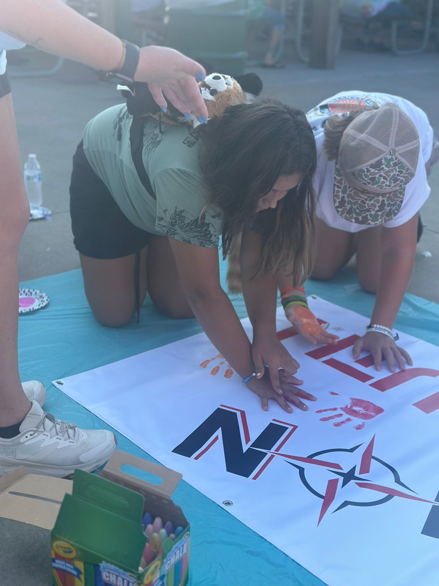 A man and a woman are kneeling on a towel with a sign that says n on it