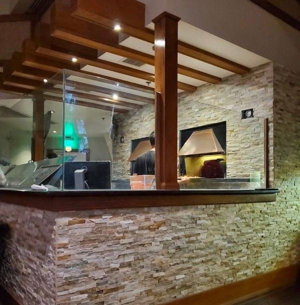 A counter in a restaurant with a brick wall