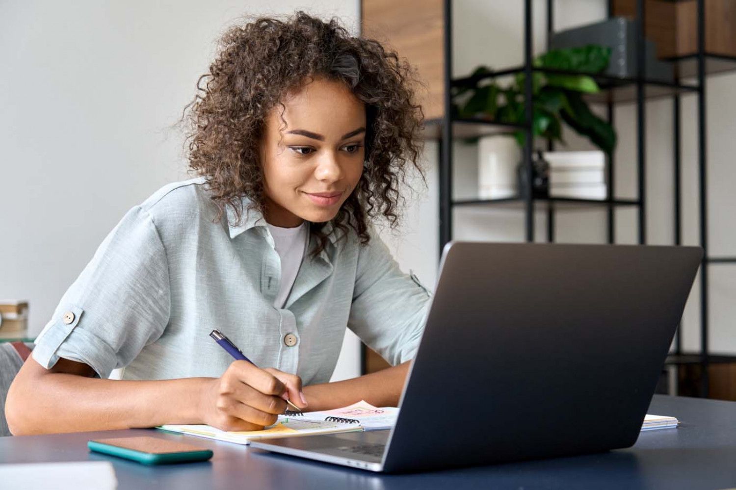 happy female student studying using a laptop