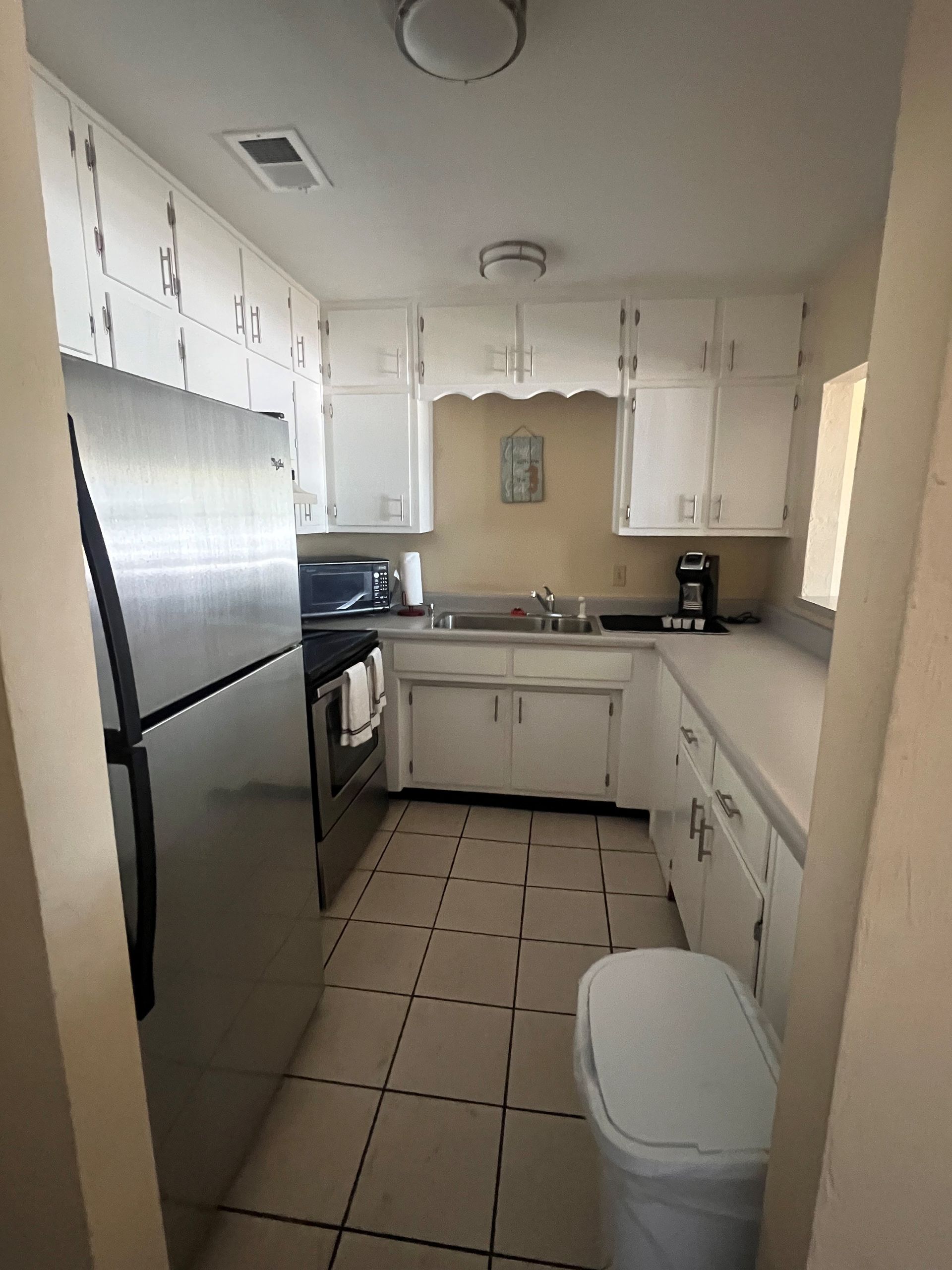A kitchen with stainless steel appliances and white cabinets