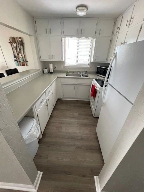 A kitchen with white cabinets and a white refrigerator