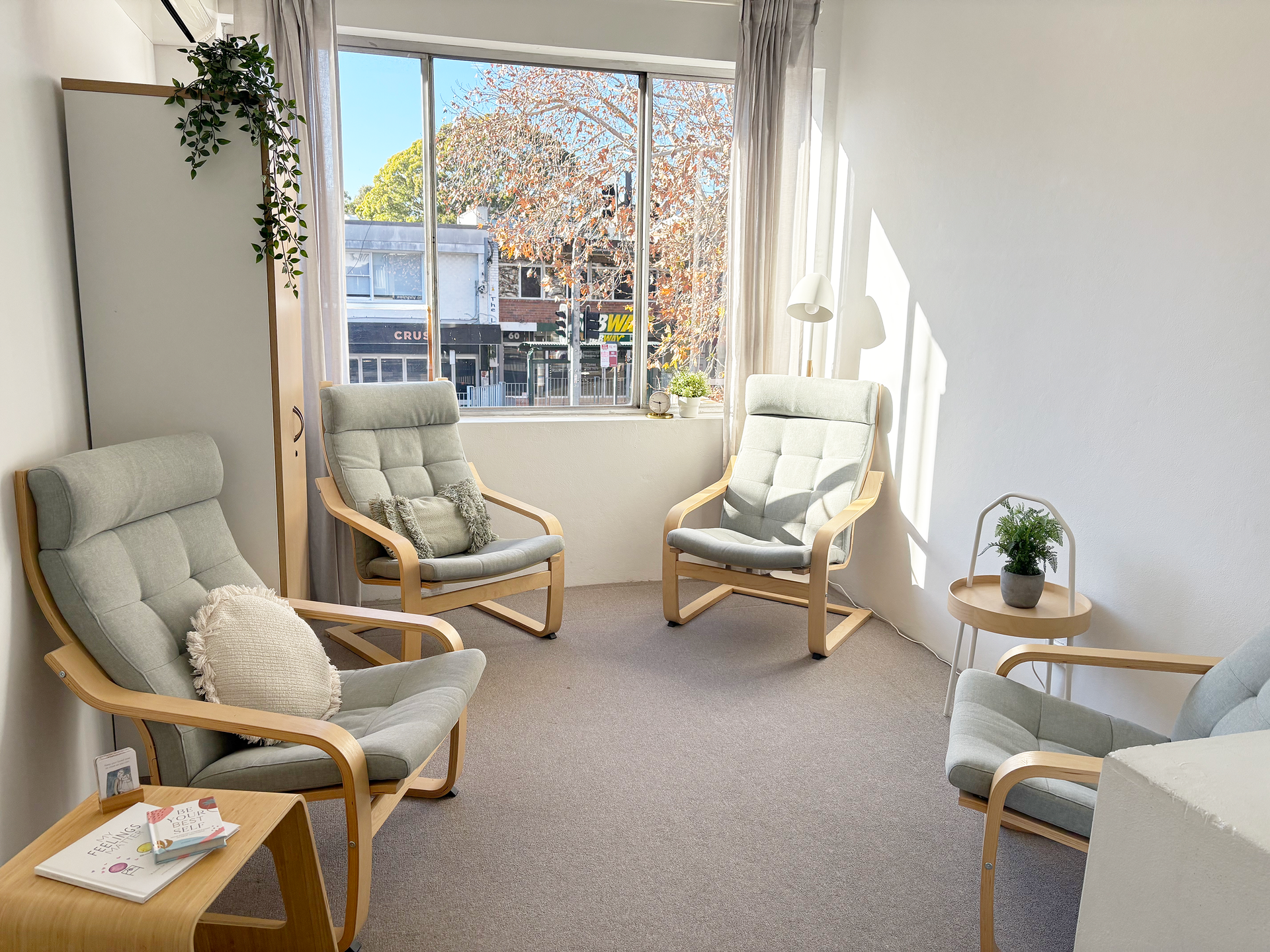 A living room with three chairs and a window.