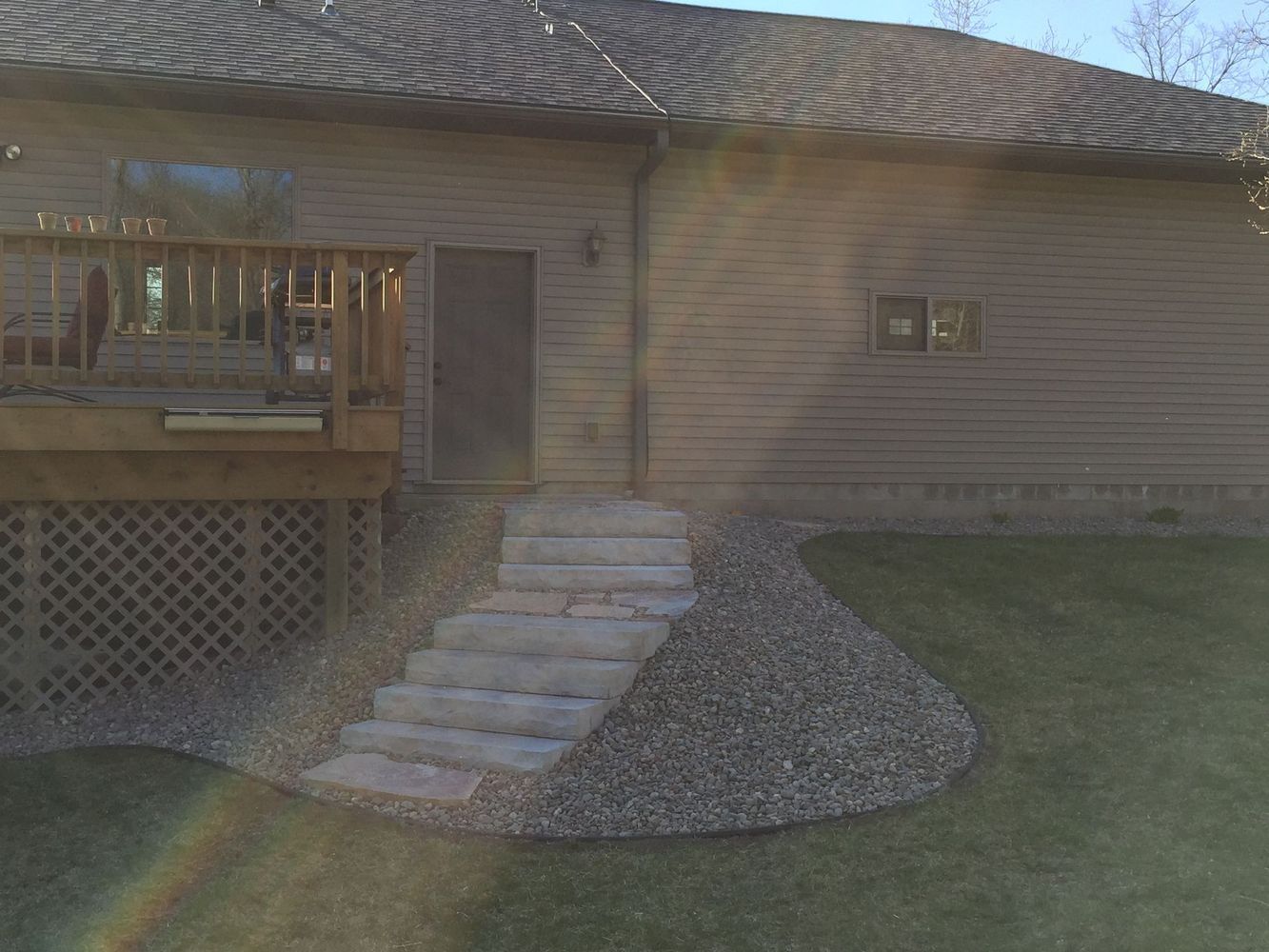 House exterior with a small stone staircase leading to a front door and a wooden porch