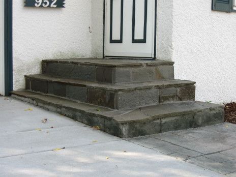 Concrete steps leading to a white front door on a stucco house entrance