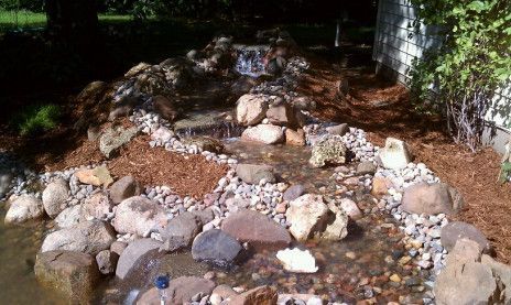 Rock garden with assorted stones and pebbles in a shaded outdoor yard
