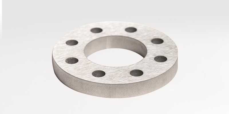 Ein Metallring mit Löchern auf weißem Hintergrund.