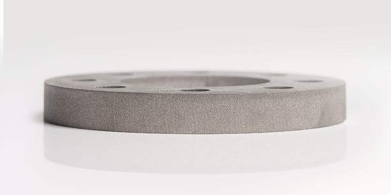 Eine Nahaufnahme eines Metallrings auf einer weißen Oberfläche.