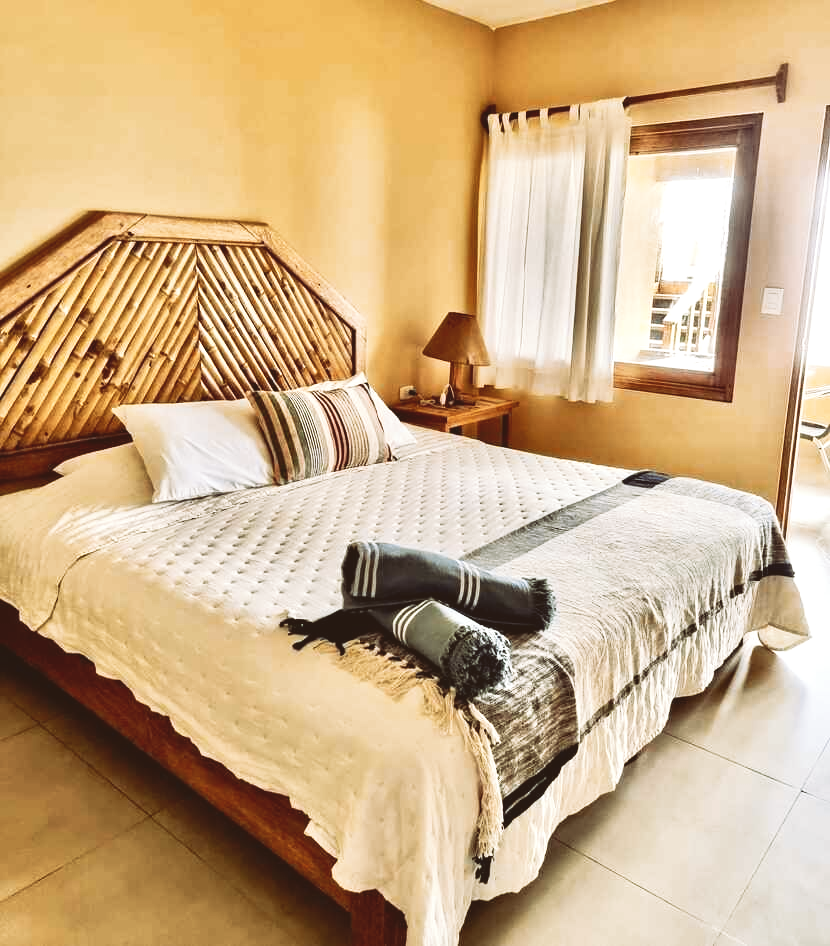 A bedroom with a large bed and a wooden headboard