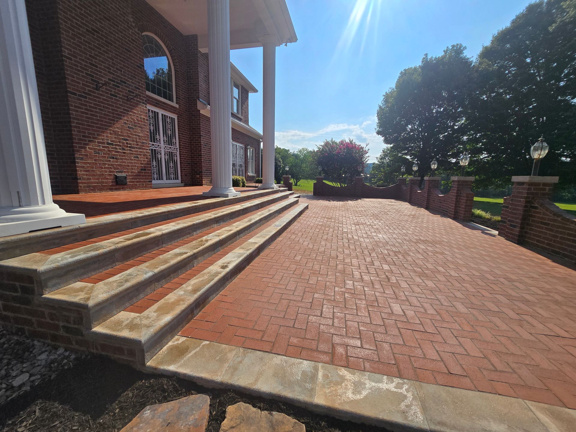 Brick walkway and steps leading to a building entrance on a sunny day