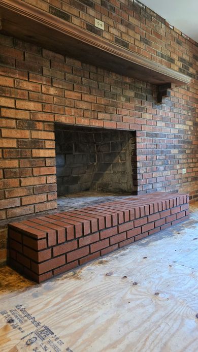 Partially built brick fireplace with a large open firebox in an unfinished room