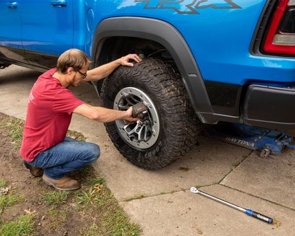 Close-up of two black automotive tires with detailed tread patterns and alloy wheels, conveying precision, durability, and performance.