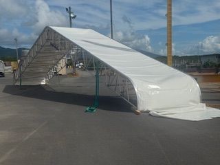 Large Tent Under Construction With Stacked Wooden Planks — T & T Scaffolding in Gordonvale, QLD