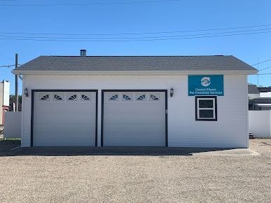 Small white two-car garage building with a blue sign under a clear sky
