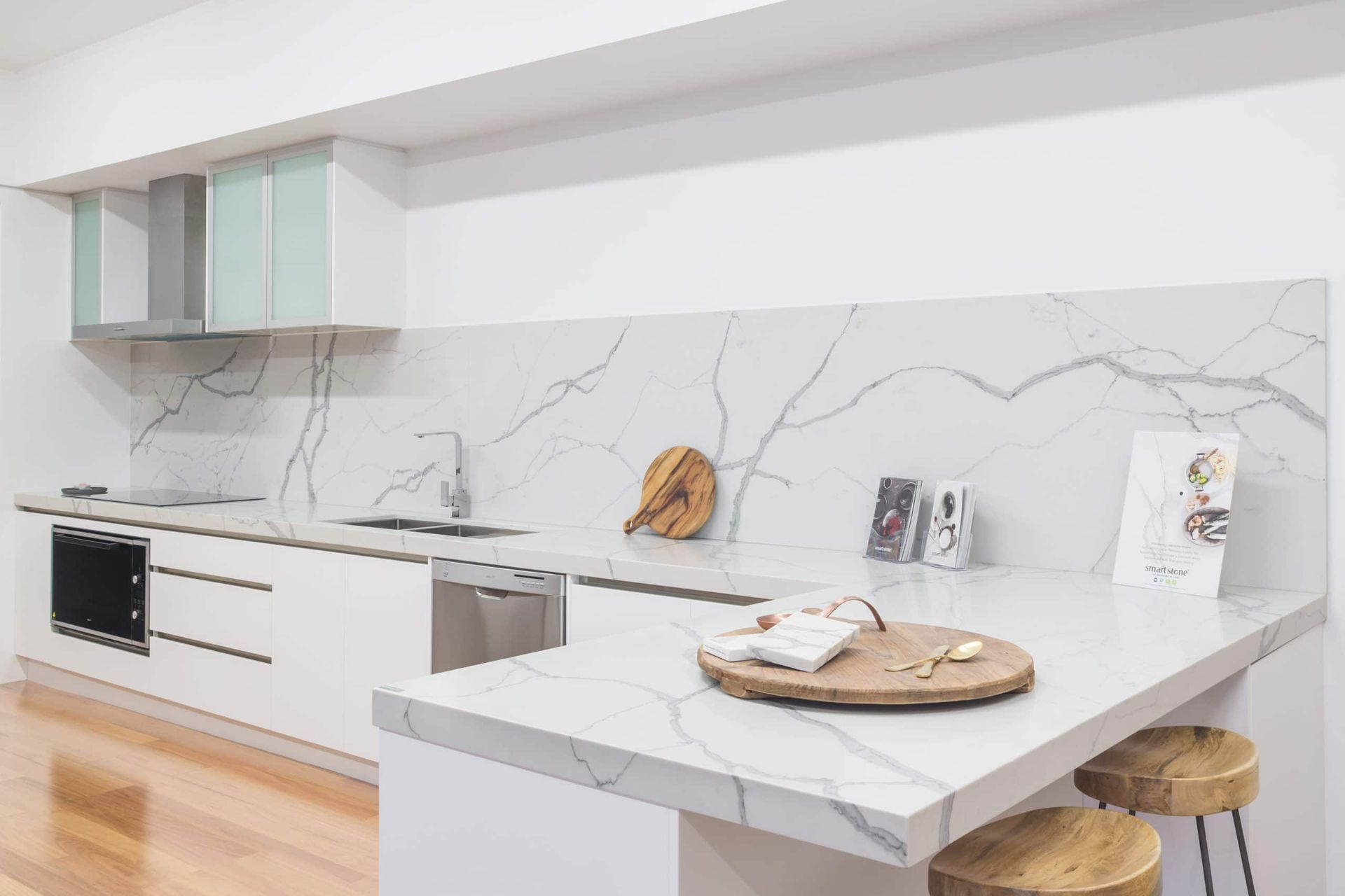 White Kitchen With Marble Countertops, Stainless Steel Appliances, and Wooden Stools — Akyrah Kitchens in Gympie, QLD