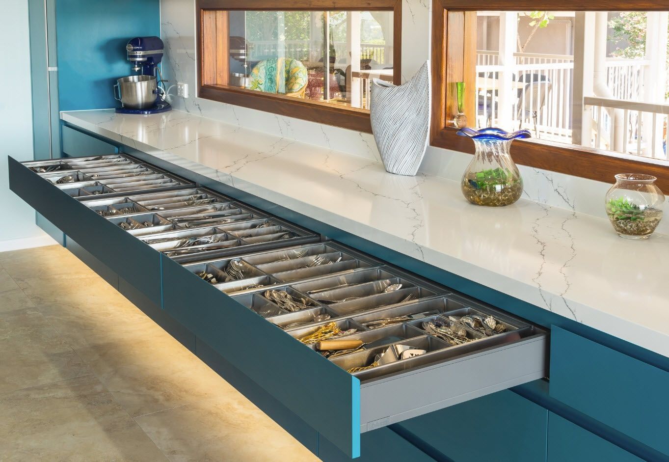 A Teal Kitchen Cabinet With a Drawer Open, Holding Silverware, Beneath a White Countertop — Akyrah Kitchens in Gympie, QLD