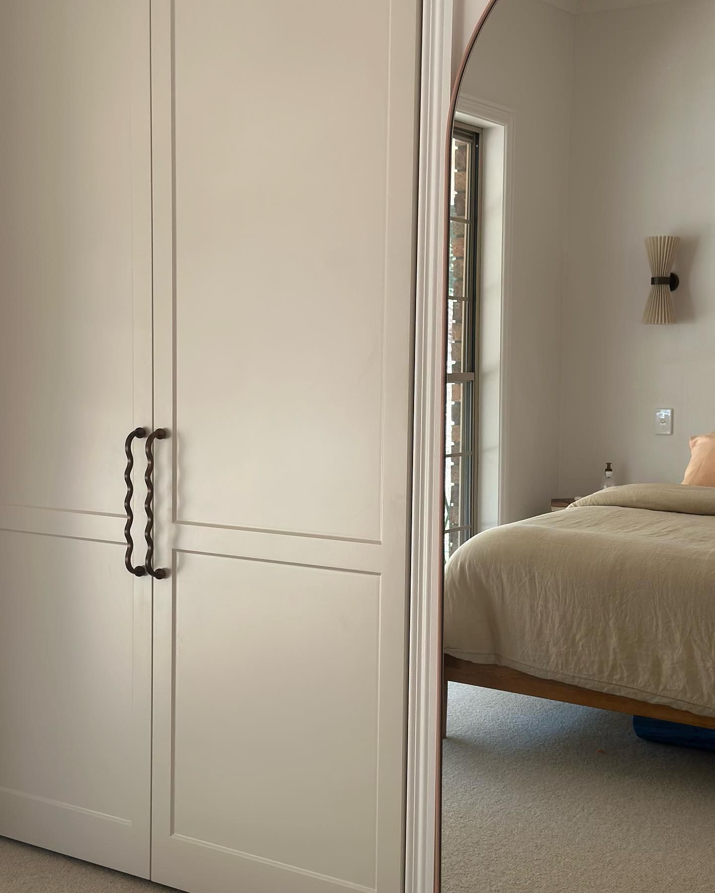 Closet With Black Handles, Reflected in a Curved Mirror, Showing a Bed and Window in a Room — Akyrah Kitchens in Gympie, QLD