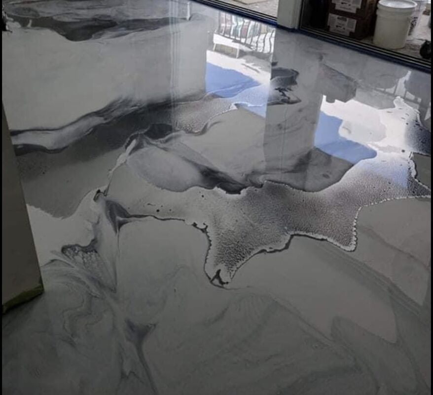 Glossy gray marble-patterned countertop with reflective surface and window light reflections