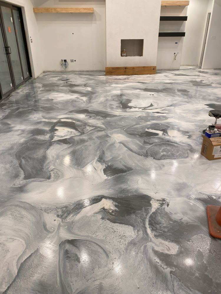Glossy gray-and-white marbled floor in a mostly empty room with built-in shelves and a small wall opening.