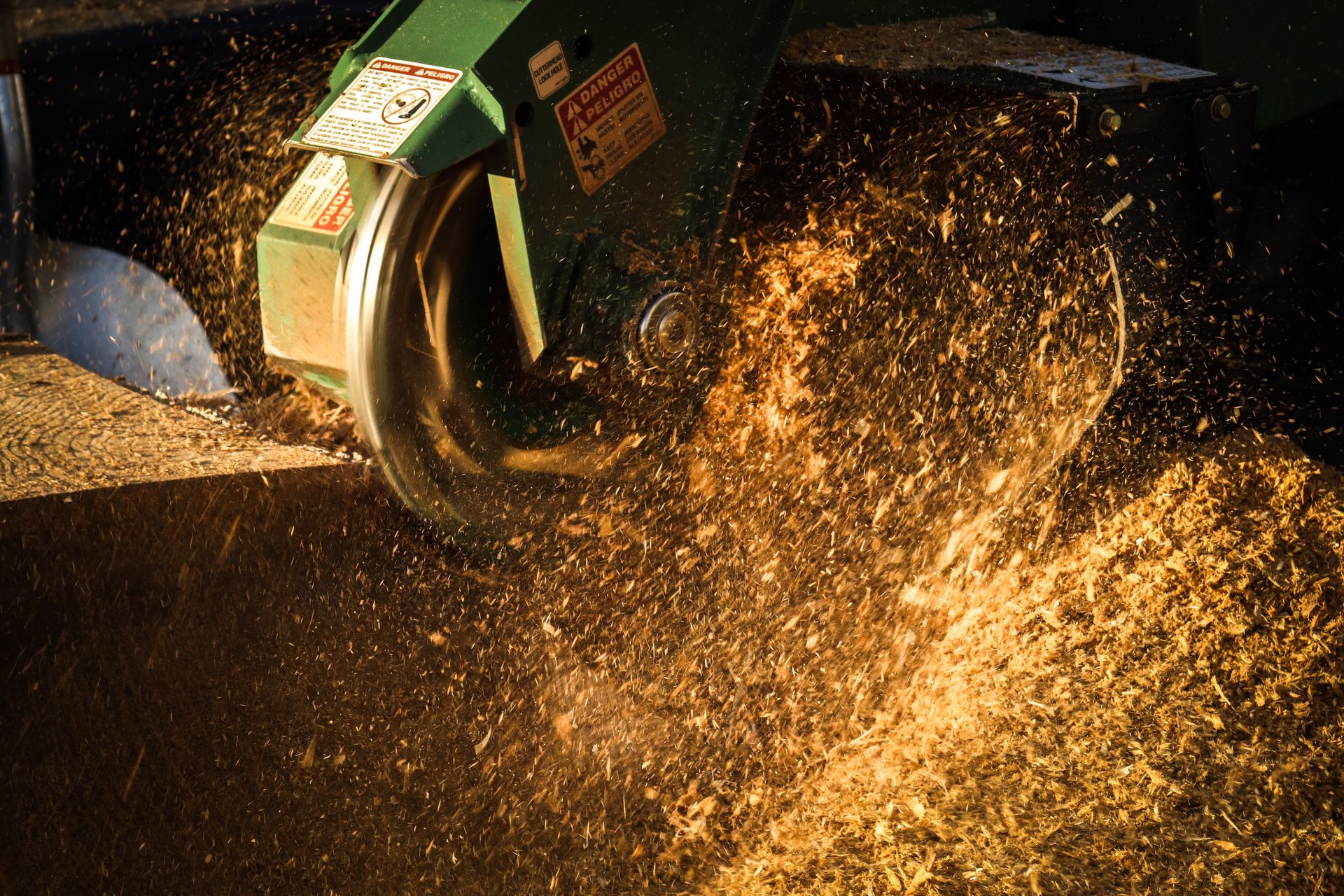 Close-up of a wood chipper ejecting a spray of wood chips into the air