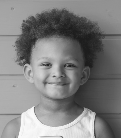 Monochrome image of a boy with a soft smile.