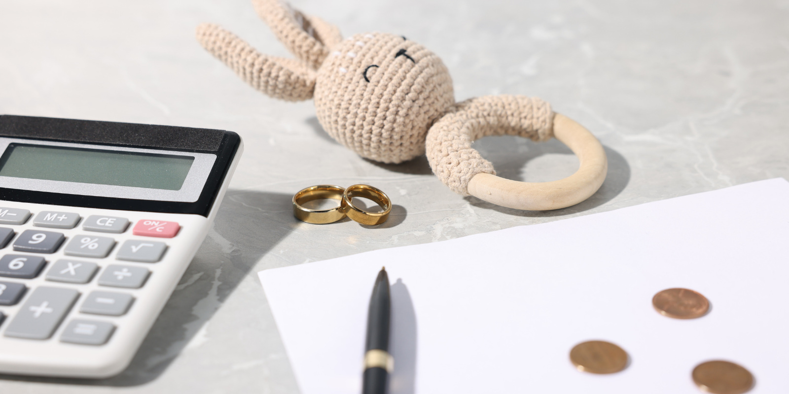 Calculator, pen, rope, and coins on a desk beside a sheet of paper, suggesting budgeting or finance.