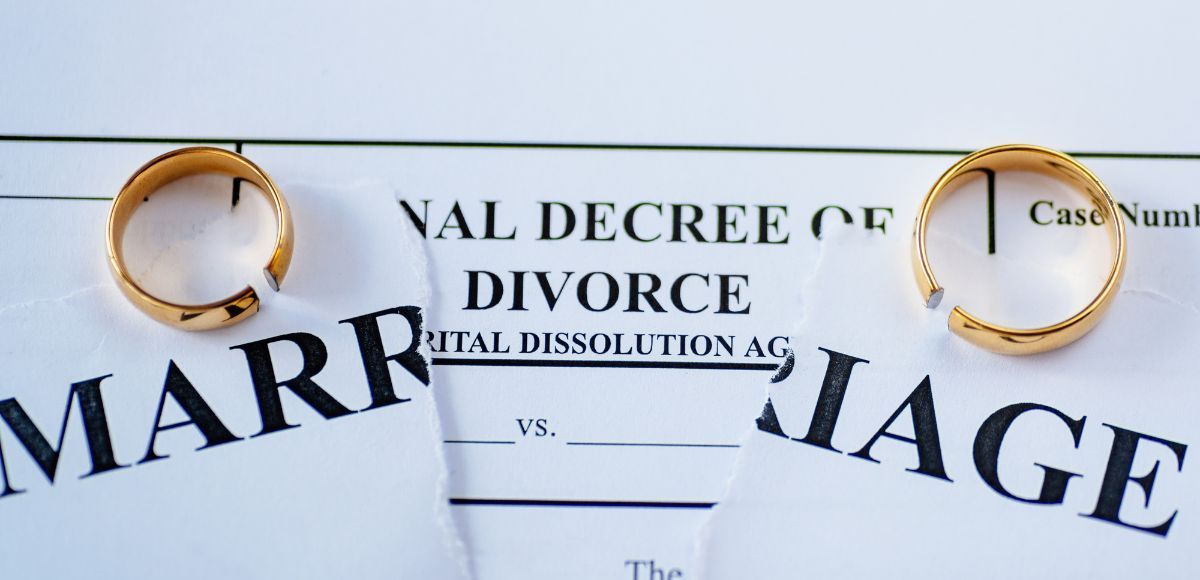 Wedding rings on divorce papers and a torn marriage certificate in California.