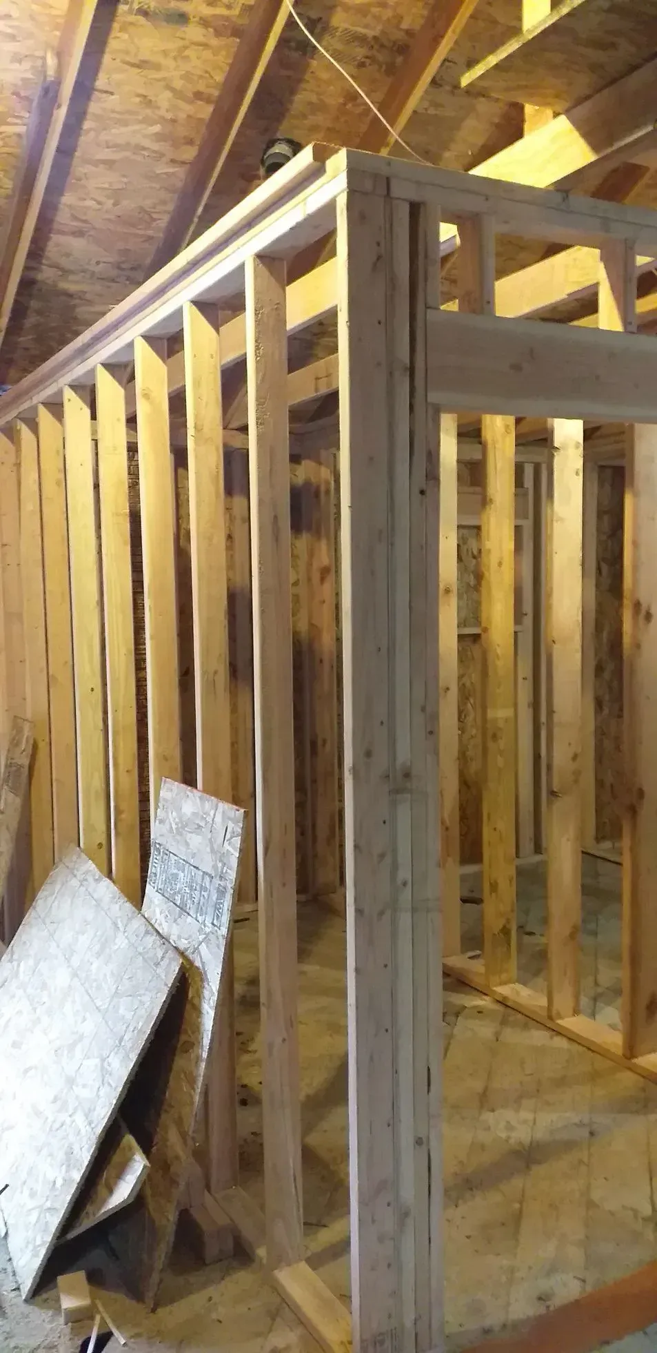 Framed interior of a house under construction with exposed wooden studs and insulation boards