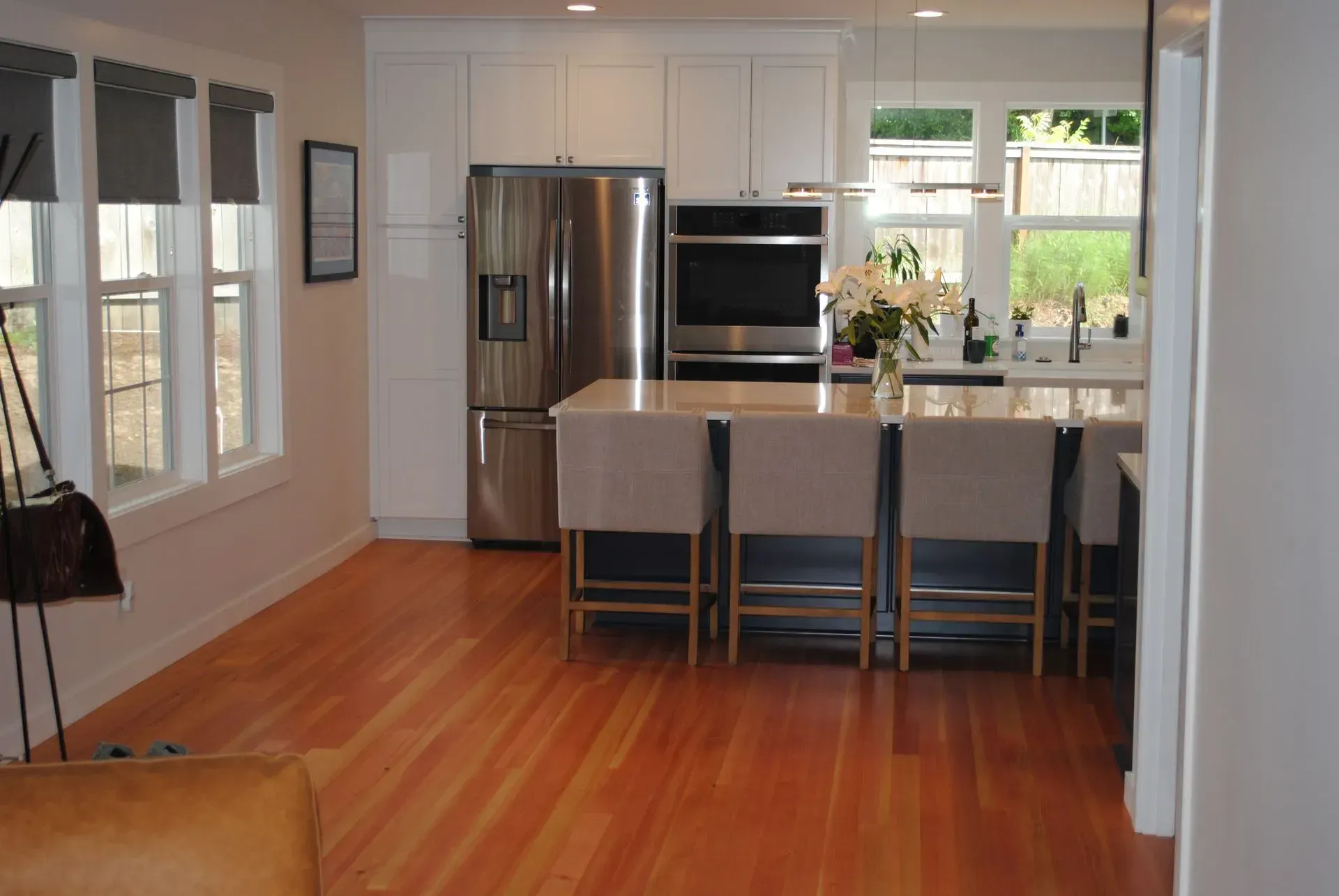 Modern kitchen and dining area with stainless steel appliances, island seating, and large windows