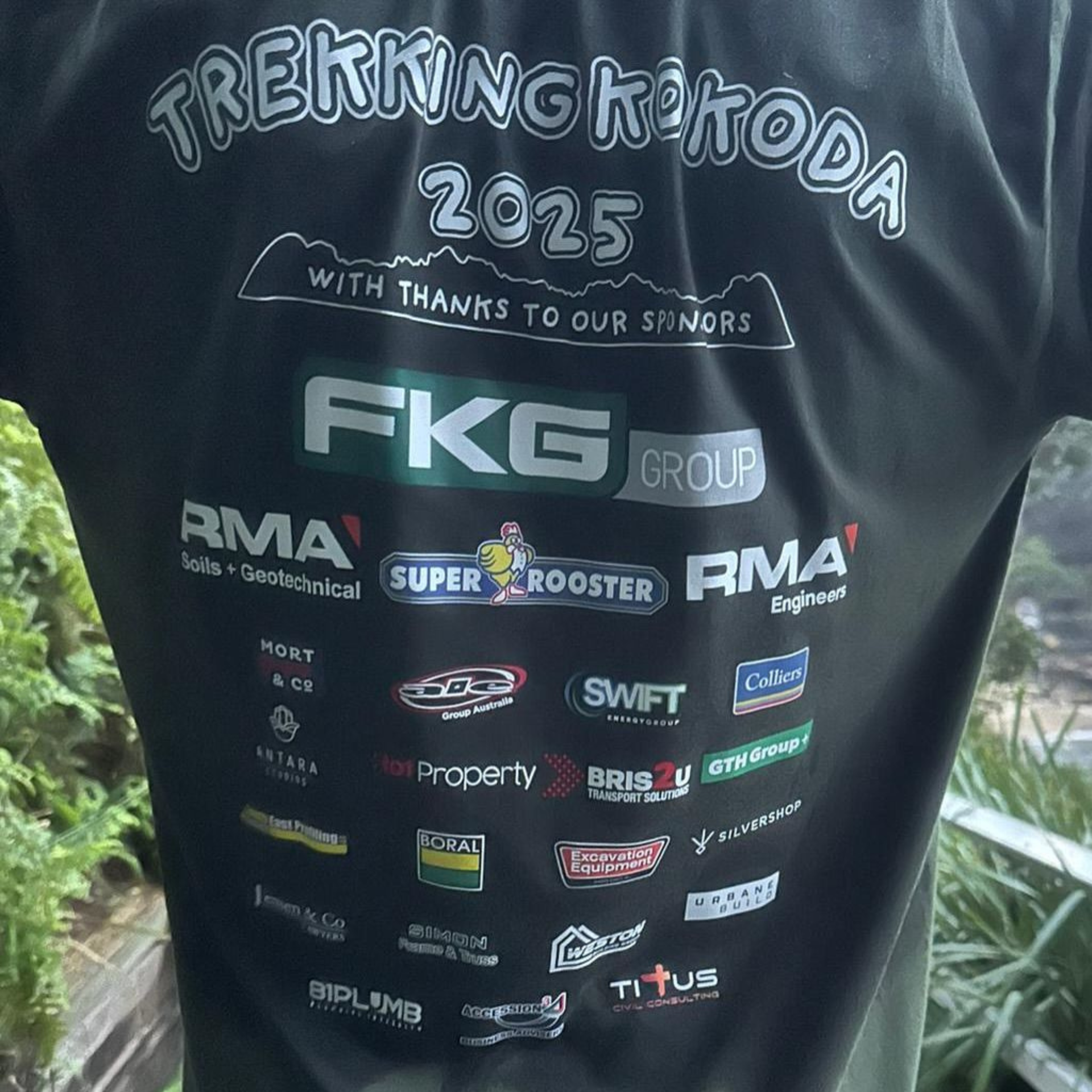 Back of black event shirt with “Trekking Kokoda 2025” and sponsor logos including Swift Energy Group.