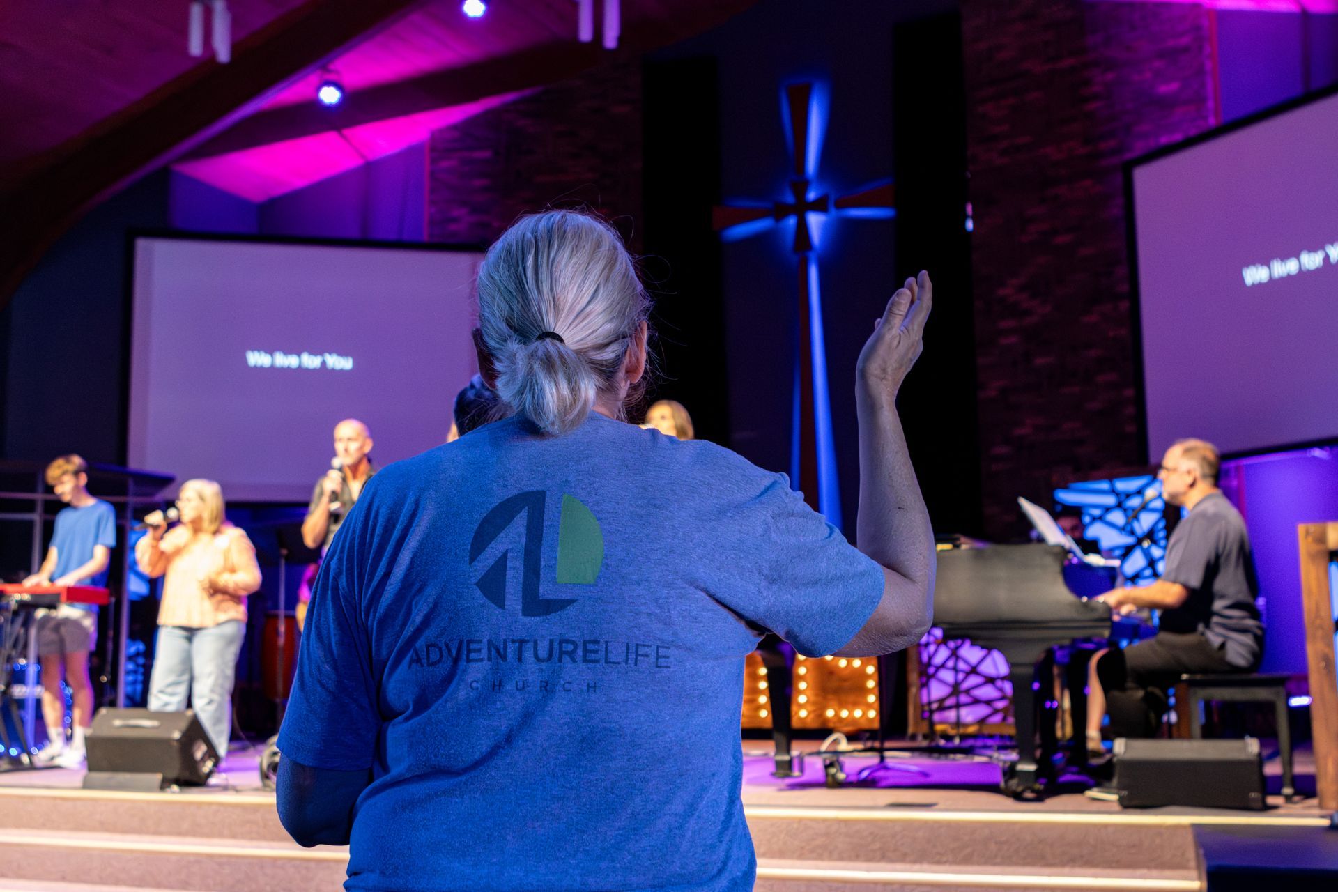 A group of people are singing and playing keyboards in a church.