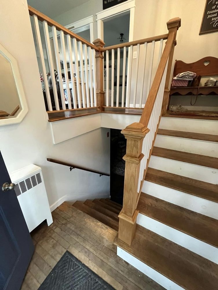 Staircase with wooden steps and railing, leading down to a lower level.