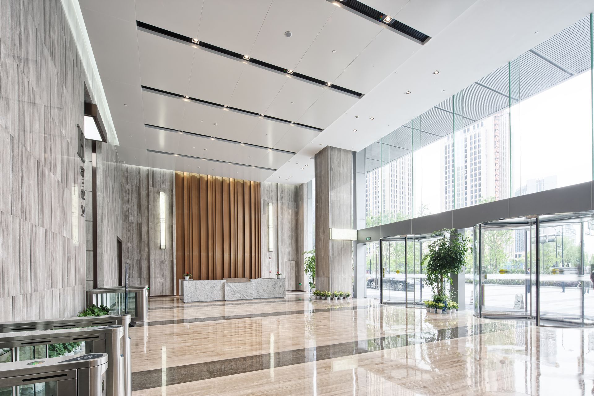A large lobby in a building with lots of windows and a reception desk.