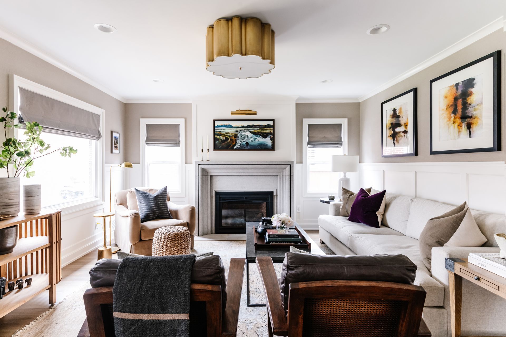 Elegant living room with woven Roman shades, custom window treatments, and a cozy fireplace seating area