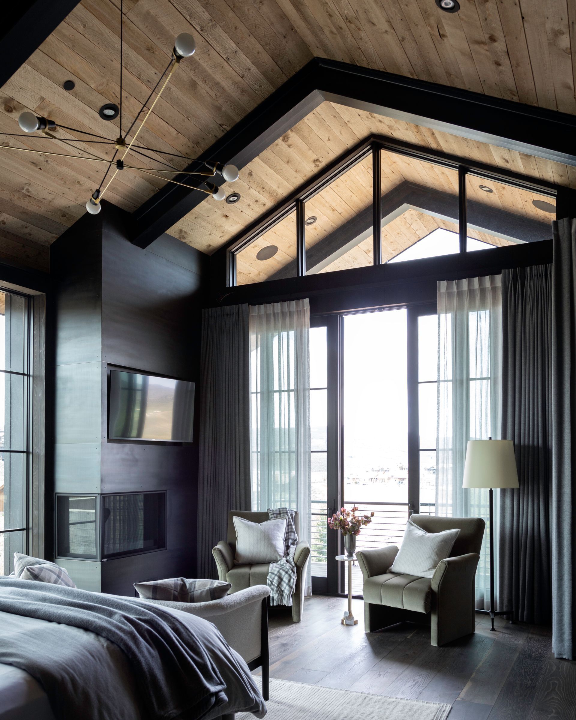 Vaulted ceiling living space with tall windows, curtain panels, wood ceiling, and modern chandelier