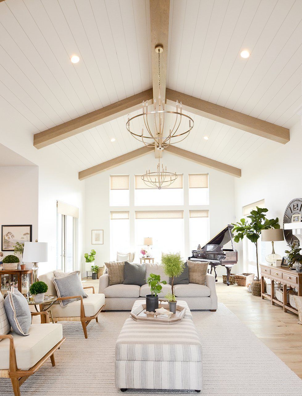 Vaulted ceiling with exposed wood beams and modern chandelier in a bright, open interior space