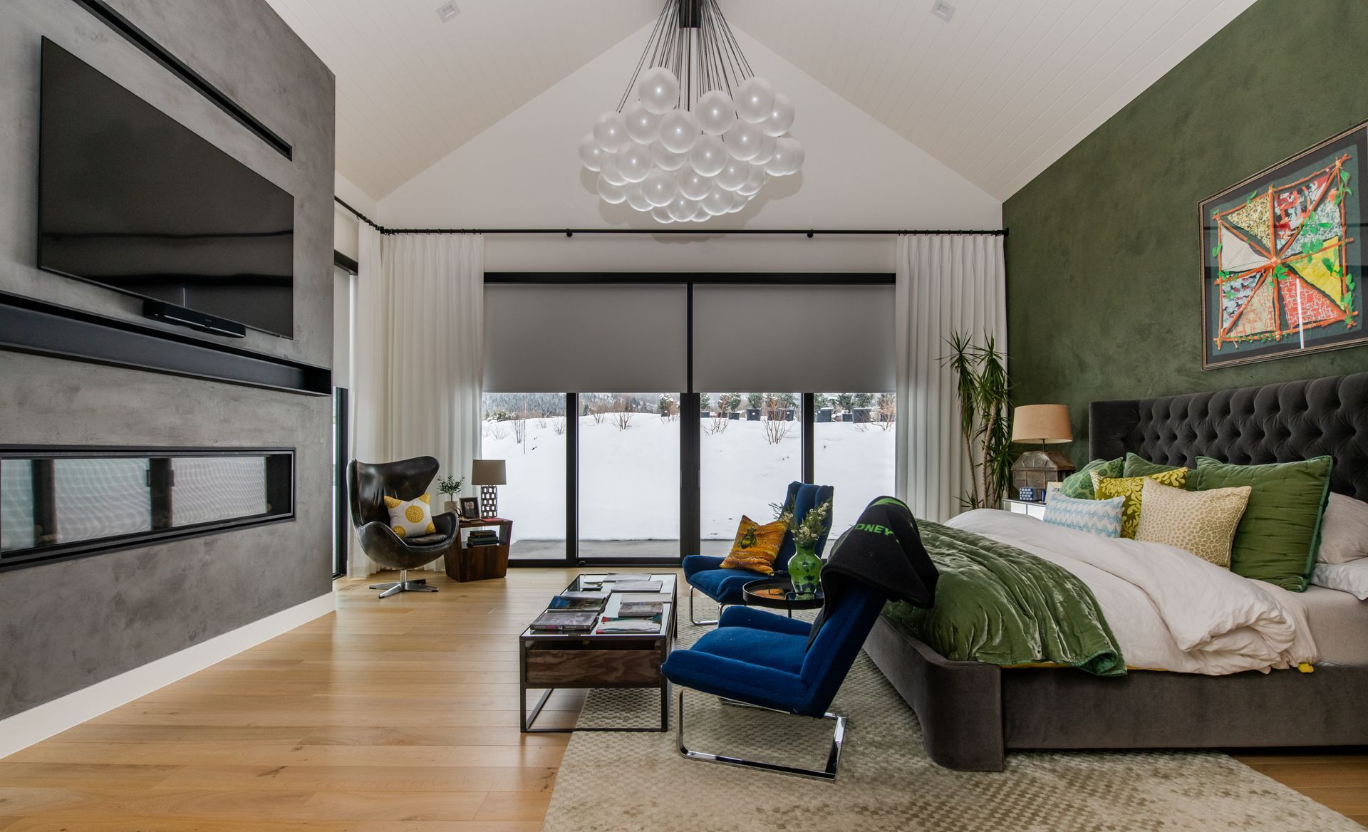 Modern bedroom with motorized blackout roller shades, large sliding doors, fireplace wall, and contemporary seating area
