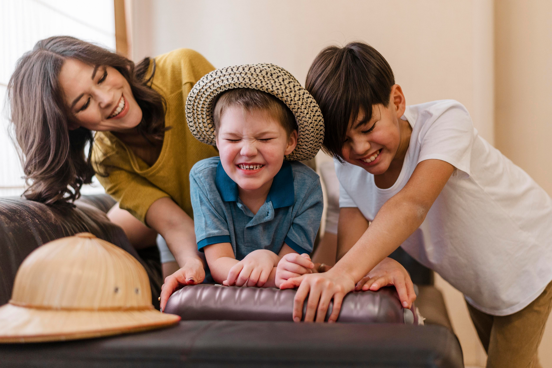 A woman and two children are playing on a couch. Family Friendly Safari