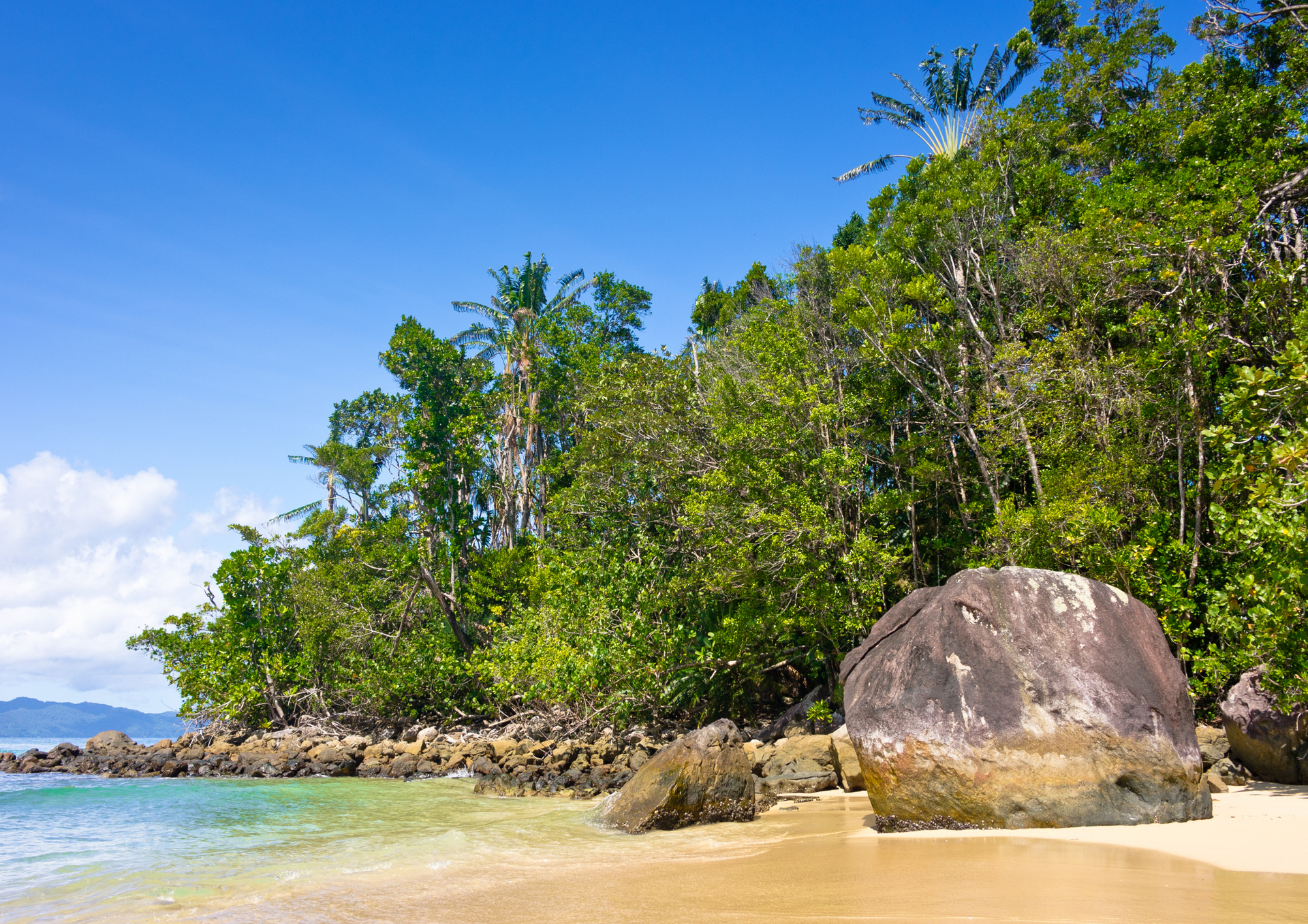 A beach with a large rock in the middle of it