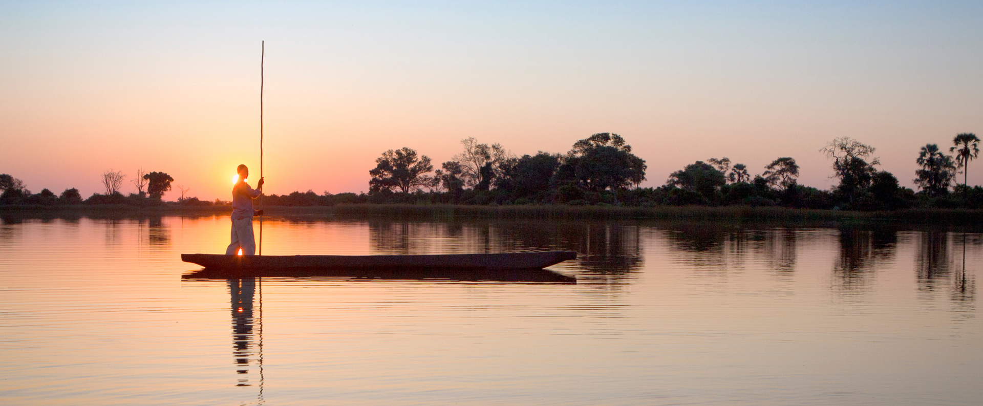 A Poler in Botswanas Okavango delta sets out in the early morning light