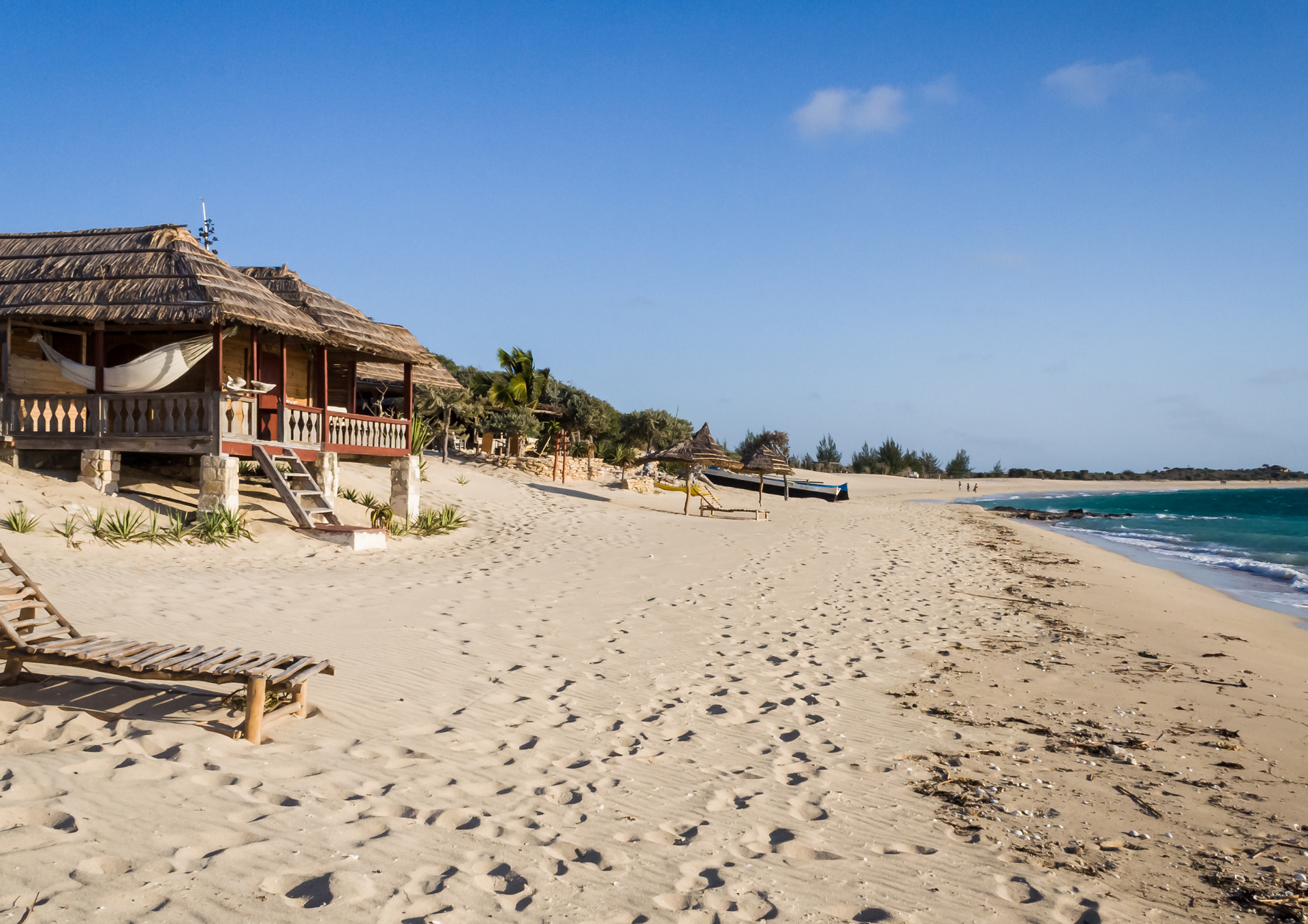 A beach with a hut and chairs on it