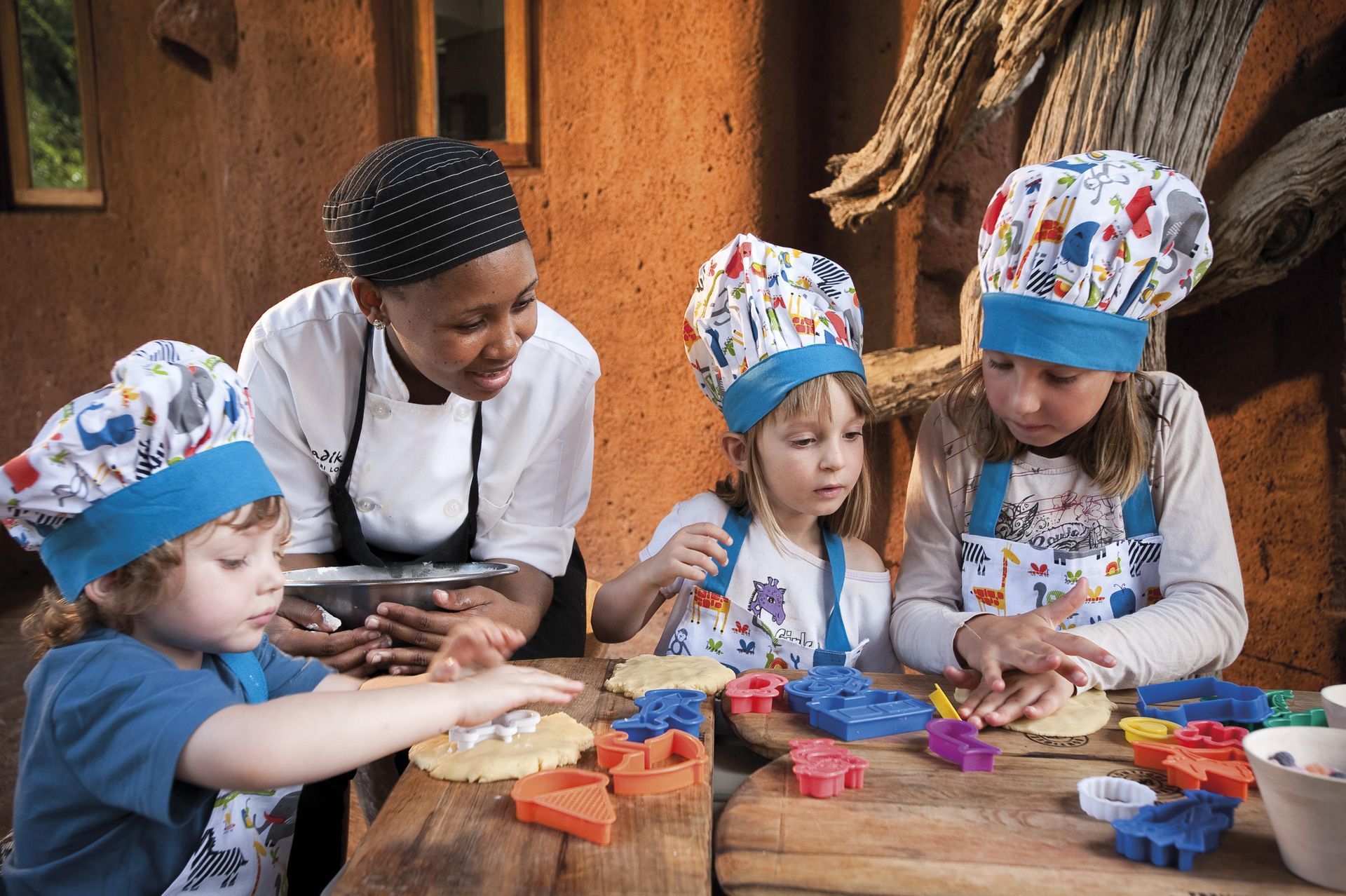 A group of children are sitting at a table wearing chef hats and aprons. Family Friendly Safari