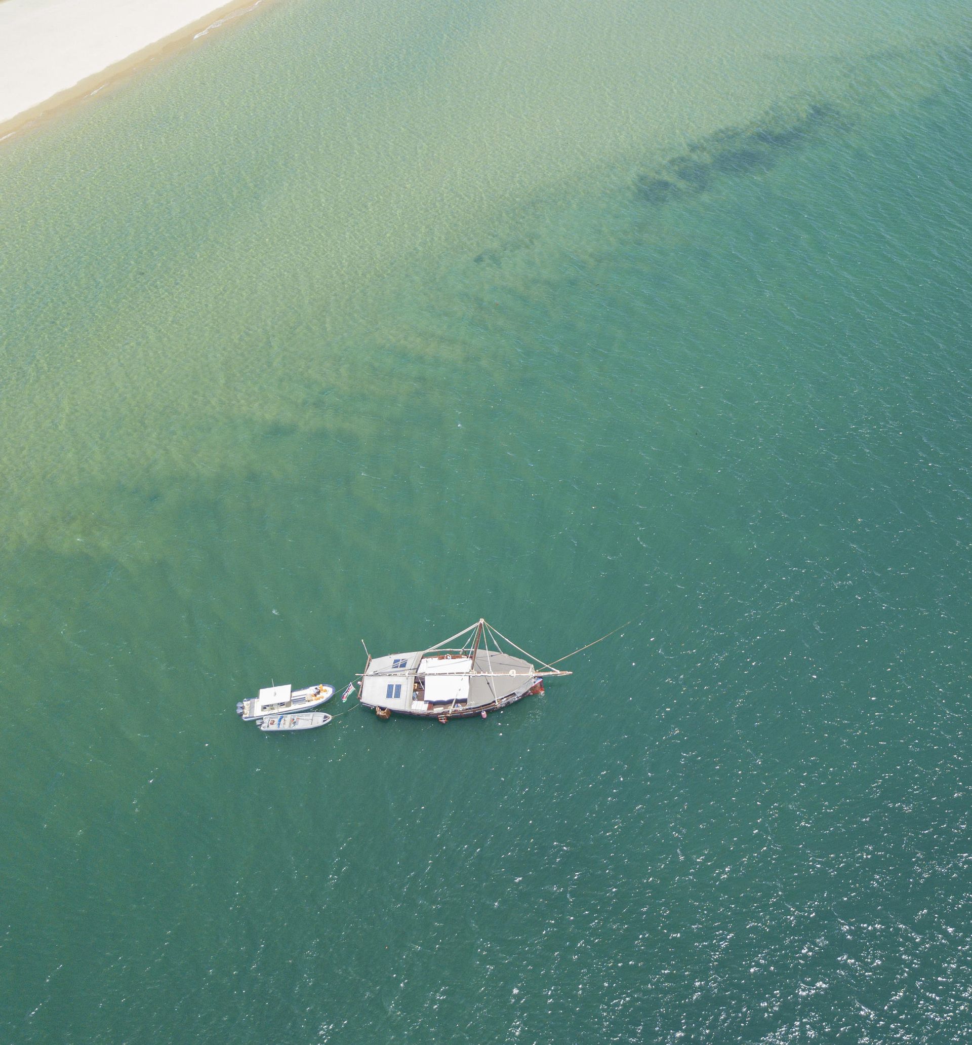 An aerial view of two boats in the water near a beach