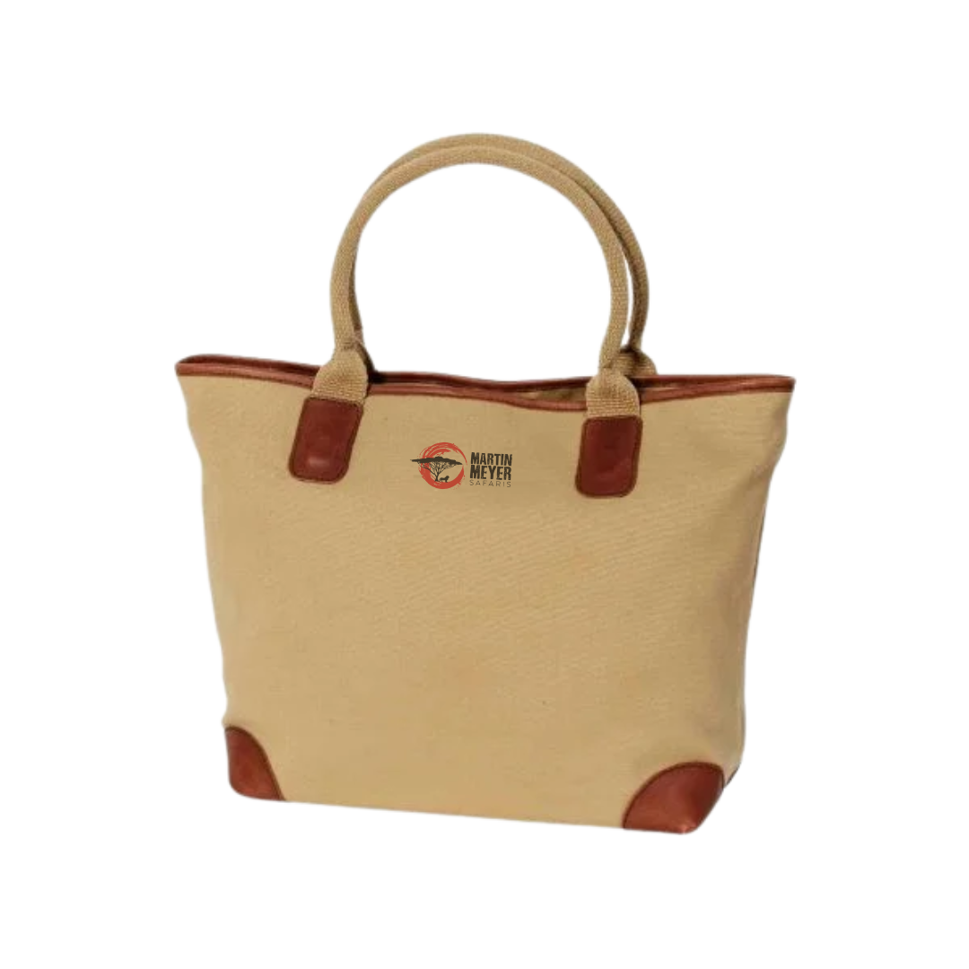 Tan canvas tote bag with brown leather accents and handles.